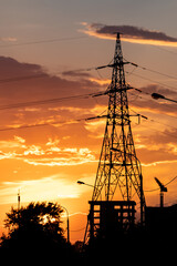 High-voltage power lines over sunset background