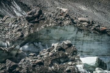 Nature background with icefall near glacier wall with cracks and scratches. Natural backdrop with icy wall and blocks of ice. Beautiful landscape with shiny glacial wall and ice blocks in sunlight.