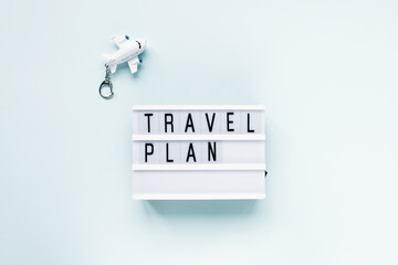 Airplane and text TRAVEL PLAN on blue background. Travelling to do list, vacation and international...