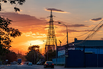 High-voltage power lines over sunset background