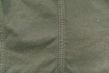 Old used dark green military cotton fabric texture, grunge, rough, dirty background. Sun bleached...