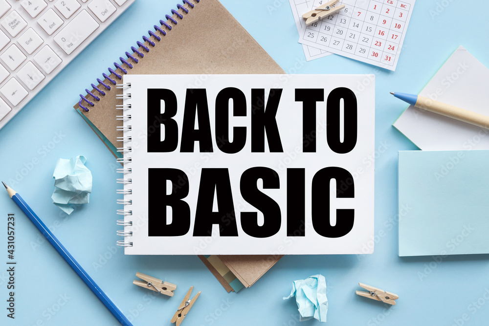 Poster back to basic. text on white notepad paper on blue background. near the blue sticks and a white keyb