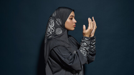 Profile of arabian woman in hijab looking at palms