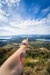 Hand pointing to a landscape of mountains in the sunset. argentina patagonia bariloche forest