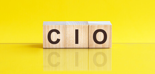 cio word is made of wooden building blocks lying on the yellow table, concept