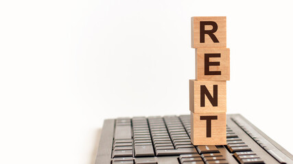 rent in 3d wooden alphabet letters on a keyboard background with copy space, business concept.