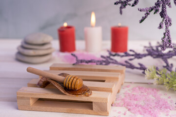 Spa salon equipment composition with flaming candles, natural honey, flaming candles, oil flasks and salt.   Depilation and beauty concept. copy space. Selective focus.	