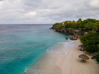 Beach and Pier at playa Kalki in Curacao, tropical beach from the sky drone view at the beach with...