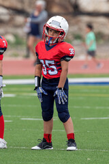 Fototapeta premium Young athletic boy playing in a youth tackle football game