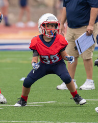 Young athletic boy playing in a youth tackle football game