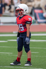 Fototapeta premium Young athletic boy playing in a youth tackle football game