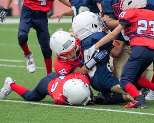 Young athletic boy playing in a youth tackle football game