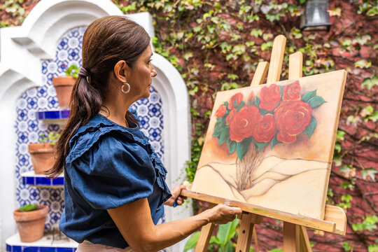 hispanic senior woman painting a picture outdoors - latinx