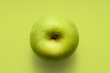 Green apple on a green background. Top view.