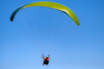 Cloudless photo of two people paragliding in blue sky