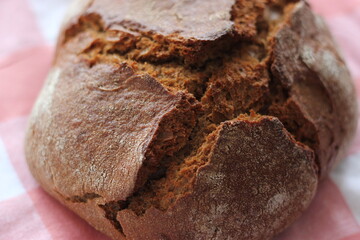 Homemade bread on a red checkered tablecloth. Closeup