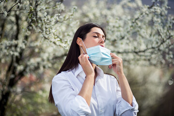 Portrait of a young and beautiful girl who puts medical mask on her face