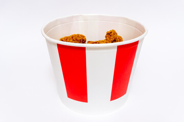 Deep fried spicy chicken wings in a crispy breading in a cardboard basket, chicken fast food isolated on white background