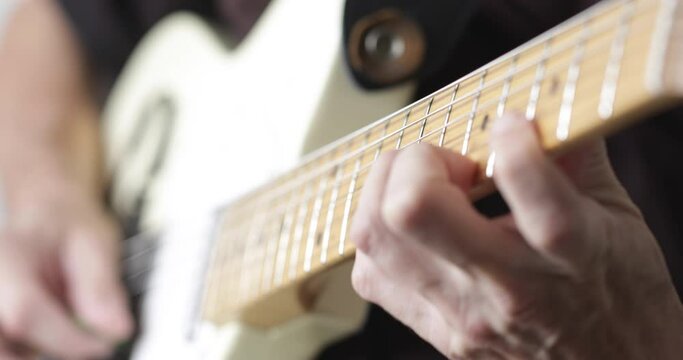Musician plays tele - type electric guitar, close-up, real people