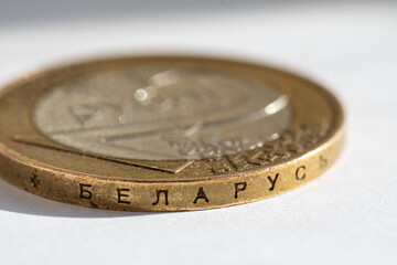 Belarusian money on a white background. Belarusian coin in macro in denominations of two rubles with an inscription on the side edge. Translation: Belarus