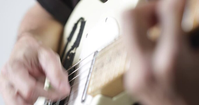 Musician plays tele - type electric guitar, close-up, real people
