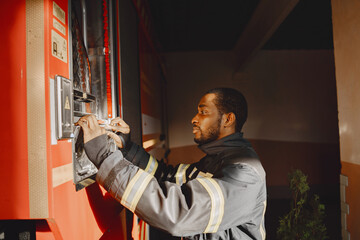 Naklejka premium Portrait of a firefighter standing in front of a fire engine