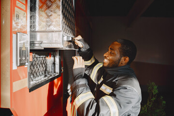 Portrait of a firefighter standing in front of a fire engine