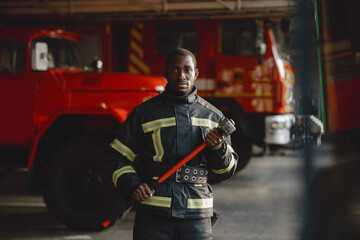 Fototapeta na wymiar Portrait of a firefighter standing in front of a fire engine