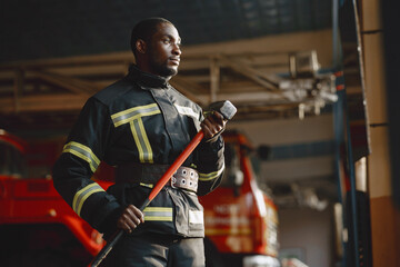 Portrait of a firefighter standing in front of a fire engine