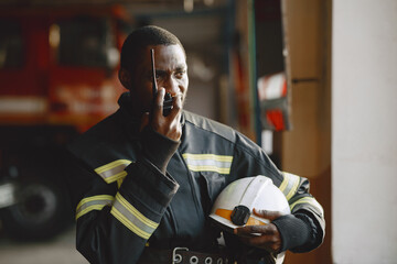 Portrait of a firefighter standing in front of a fire engine