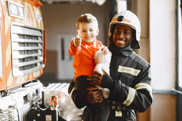 Portrait of a firefighter standing in front of a fire engine