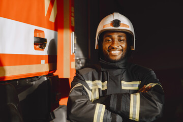 Portrait of a firefighter standing in front of a fire engine