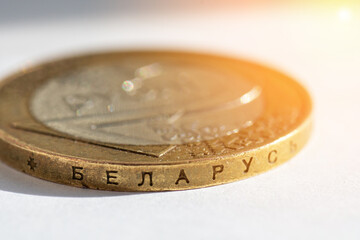 Belarusian money on a white background with flare. Belarusian coin in macro in denominations of two rubles with an inscription on the side edge. Translation: Belarus