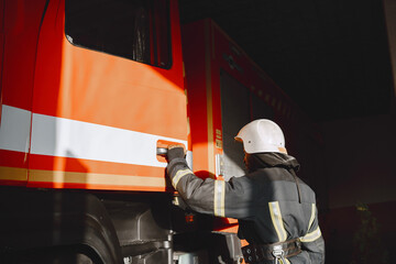 Portrait of a firefighter standing in front of a fire engine