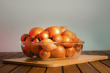  Centralized view. Healthy food. Cooking seasoning. Onions stacked in a glass bowl. Gourmet barbecue board. Clean background. Rustic wood floor