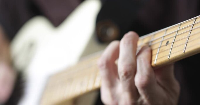 Musician plays tele - type electric guitar, close-up, real people
