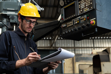 Skillful factory worker working with clipboard to do job procedure checklist . Factory production line occupation quality control concept .