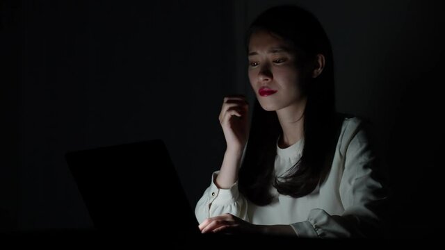 夜更かしでパソコン作業をする女性