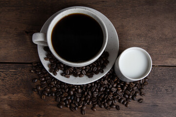 Obraz na płótnie Canvas Coffe cup with milk and coffee grains