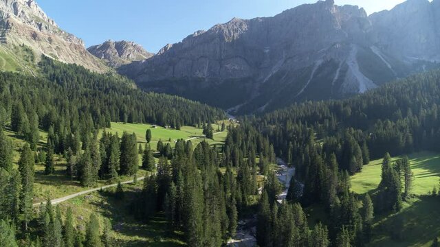 Aerial view of road passing trough forest leading up to mountain pass in the Dolomites. Beautiful nature in the Alps. Relaxing and taking in the beauty of nature