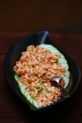 An Italian style pink sauce pasta garnished with cucumber and tomatoes.