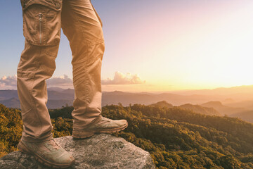 Hiker standing on top mountain sunset background. Hiker men's hiking living healthy active lifestyle.