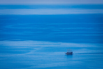 A luxury sailing ship navigates the open sea.  against the background of blue sky on a bright warm day. Excursion on a yacht in the resort area