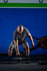 Fototapeta na wymiar Hombre haciendo ejercicios con mancuernas en gimnasio, con fondo color azul