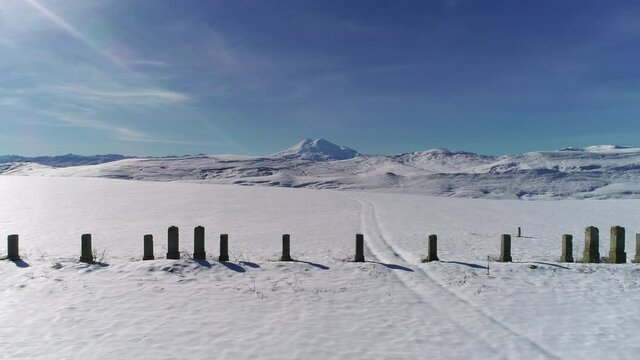 Flying along the snowy foot of the mountain