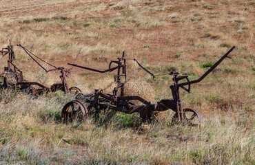 Old farm equipment in dry field