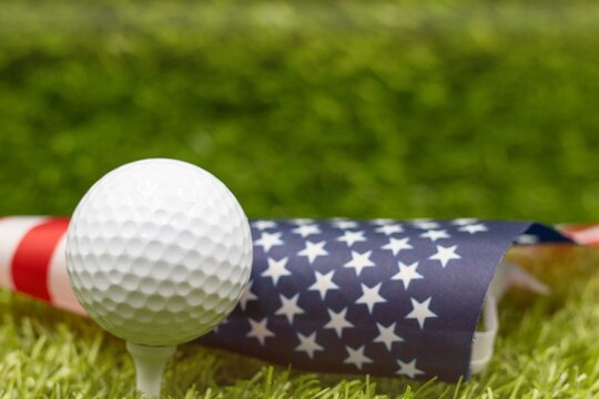 Golf ball is on American flag on green grass