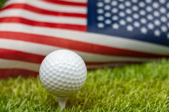 Golf ball is on American flag on green grass