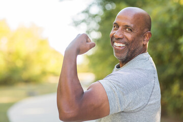 Mature African American flexing his bicep muscle.