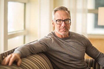 Mature man sitting on a sofa sock photo